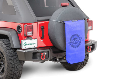 a red jeep with a blue sac hanging in the back
