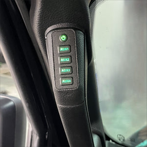 a 4 button panel with green lit buttons installed in a vehicle’s grab handle