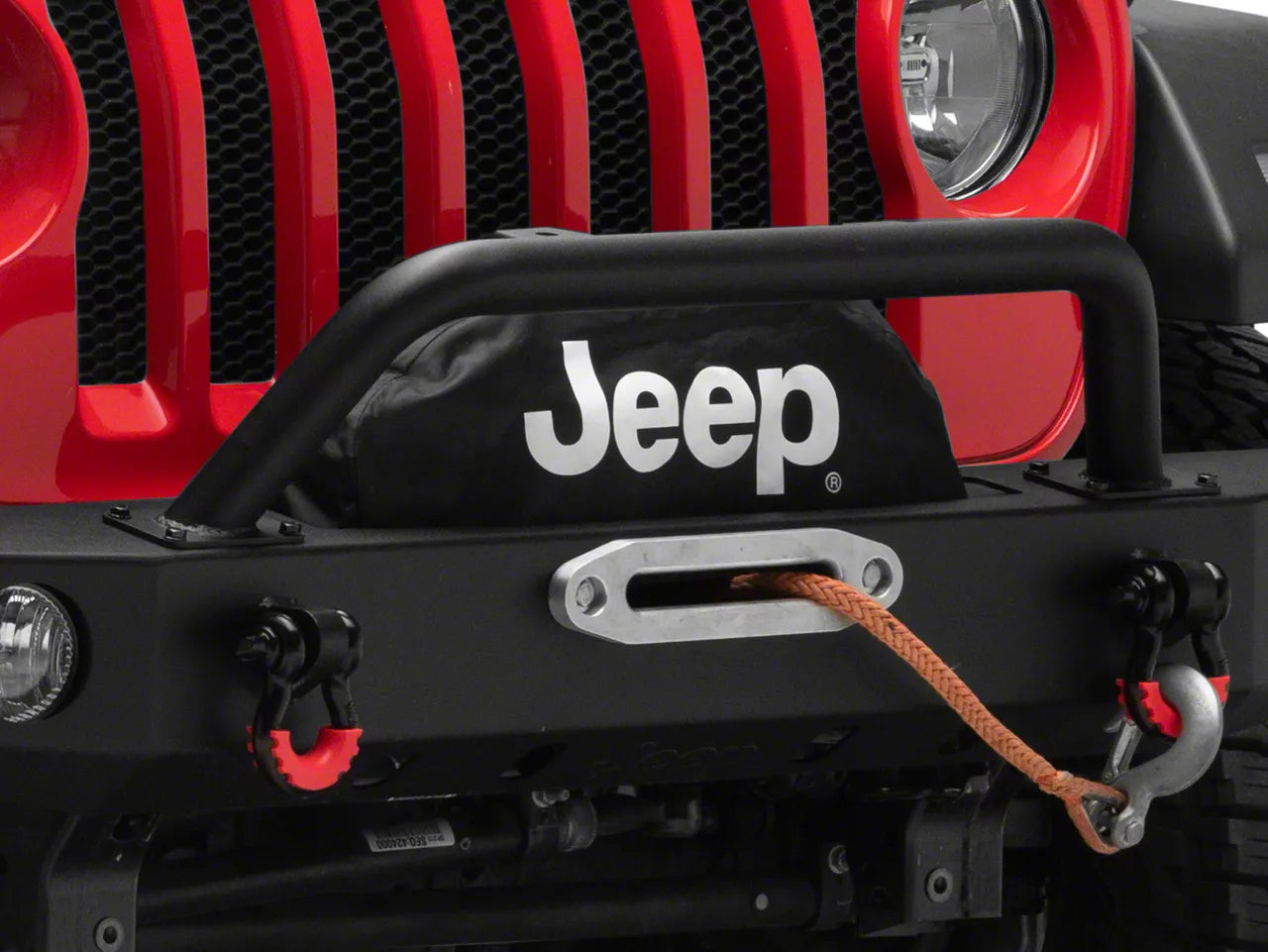 a red jeep with a visible winch line and jeep logo on winch cover