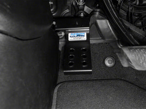 a MORE dead pedal sits installed in the floorboard of a jeep wrangler