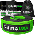 a black wrapped strap with green adornment sits in front of its packaging and carrying bag