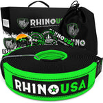 a green and black tow strap is coiled up in front of its packaging and drawstring carrying bag