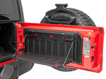 the rear door of a red vehicle is open to reveal an installed tailgate table which has been opened
